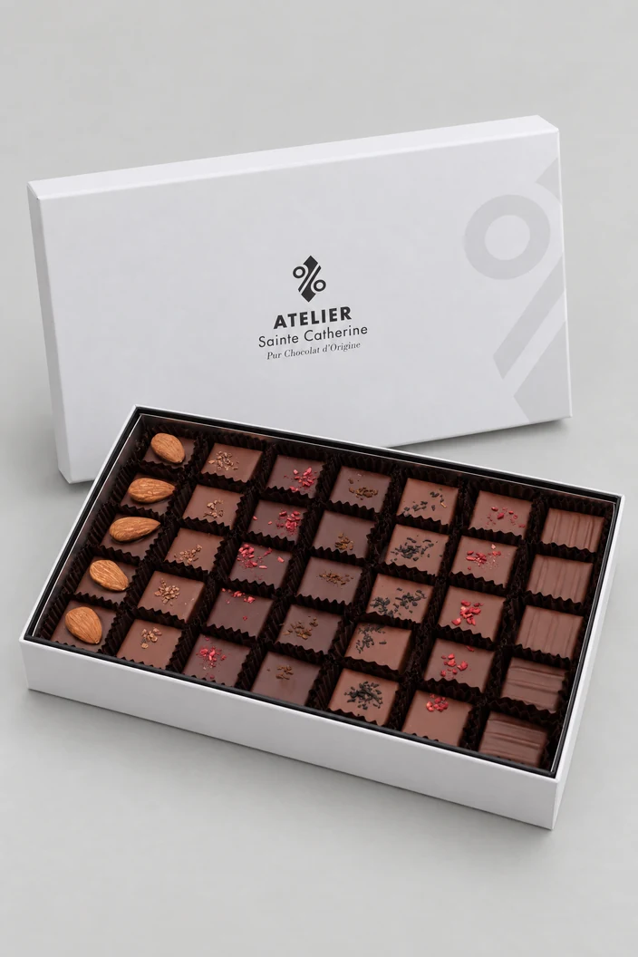 La boîte blanche de l'Atelier, ouverte sur ses pralines, son couvercle posé derrière