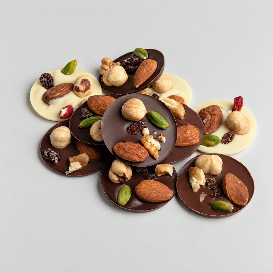 Des mendiants au chocolat noir et blanc garnis d'amandes, de noisettes, de pistaches et de raisins