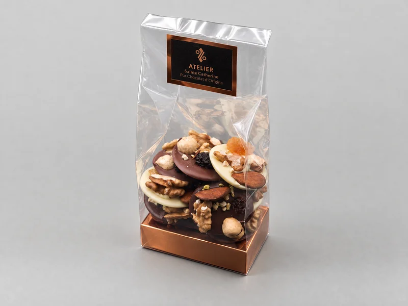 Het zakje gemengde mendiants, in witte, melk- en pure chocolade